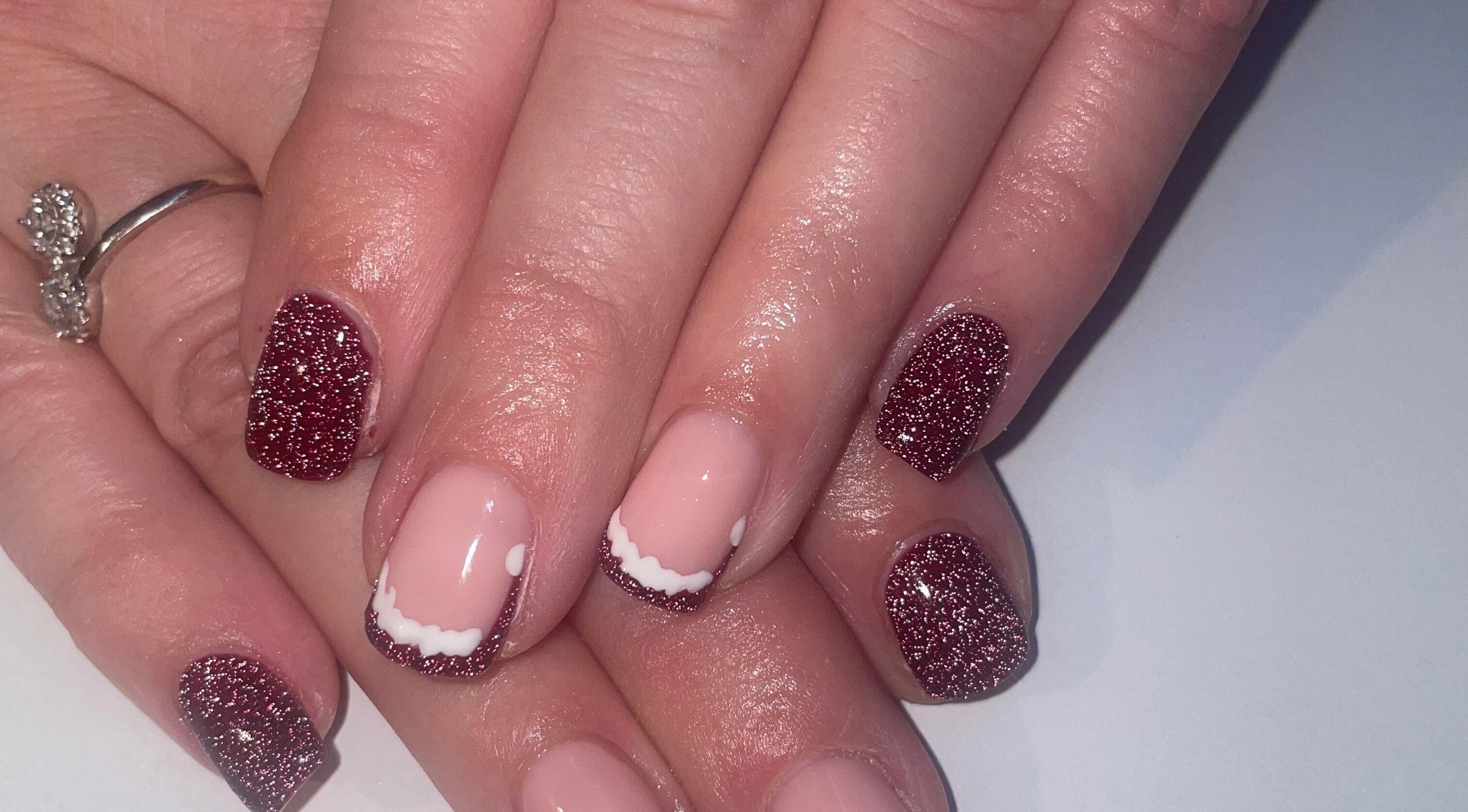 Glittery nail art design at BARE, Port Glasgow, Scotland, GB showcasing elegant ruby sparkle finish.