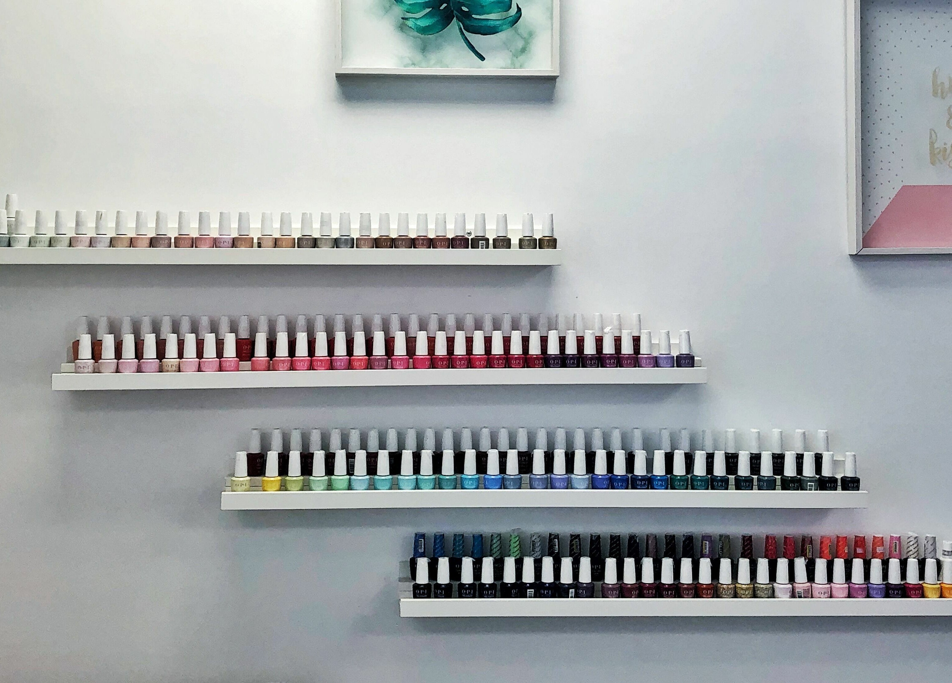 A colorful display of nail polishes at Kuo Qi Nails in Toronto, Ontario, CA, showcasing vibrant options.