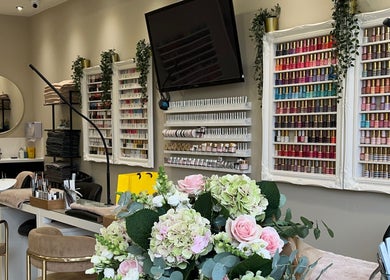 Elegant nail salon interior at The Nail Company, London, England, GB, featuring colorful polish displays.