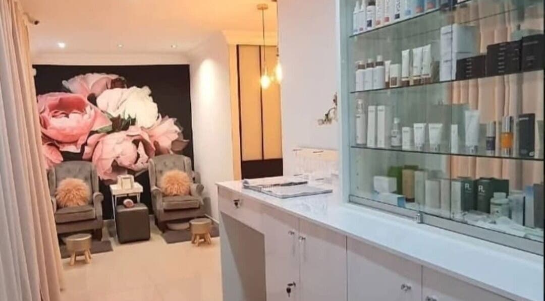 Stylish interior at Face & Body Studio SA in Boksburg, Gauteng, ZA with pink floral mural and cozy seating.