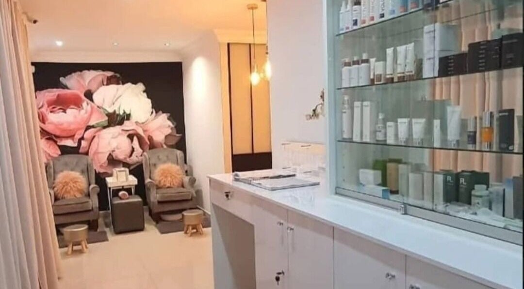 Stylish interior at Face & Body Studio SA in Boksburg, Gauteng, ZA with pink floral mural and cozy seating.