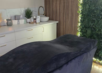 Relaxing treatment room at The Beauty Cabin, Calahonda, Andalucía, ES with green decor and plush bed.