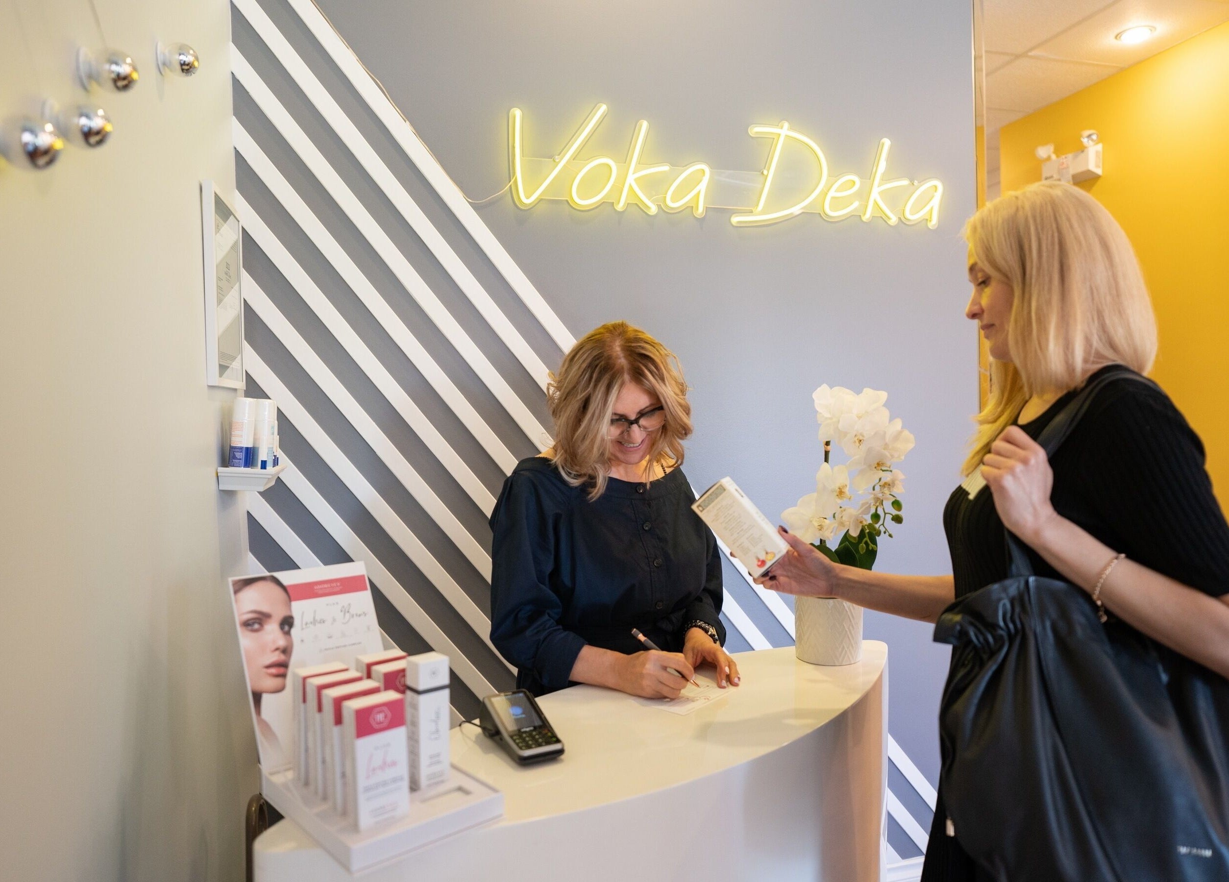 Receptionist assisting client at Voka Deka Esthetics Salon in Vancouver, British Columbia, CA.