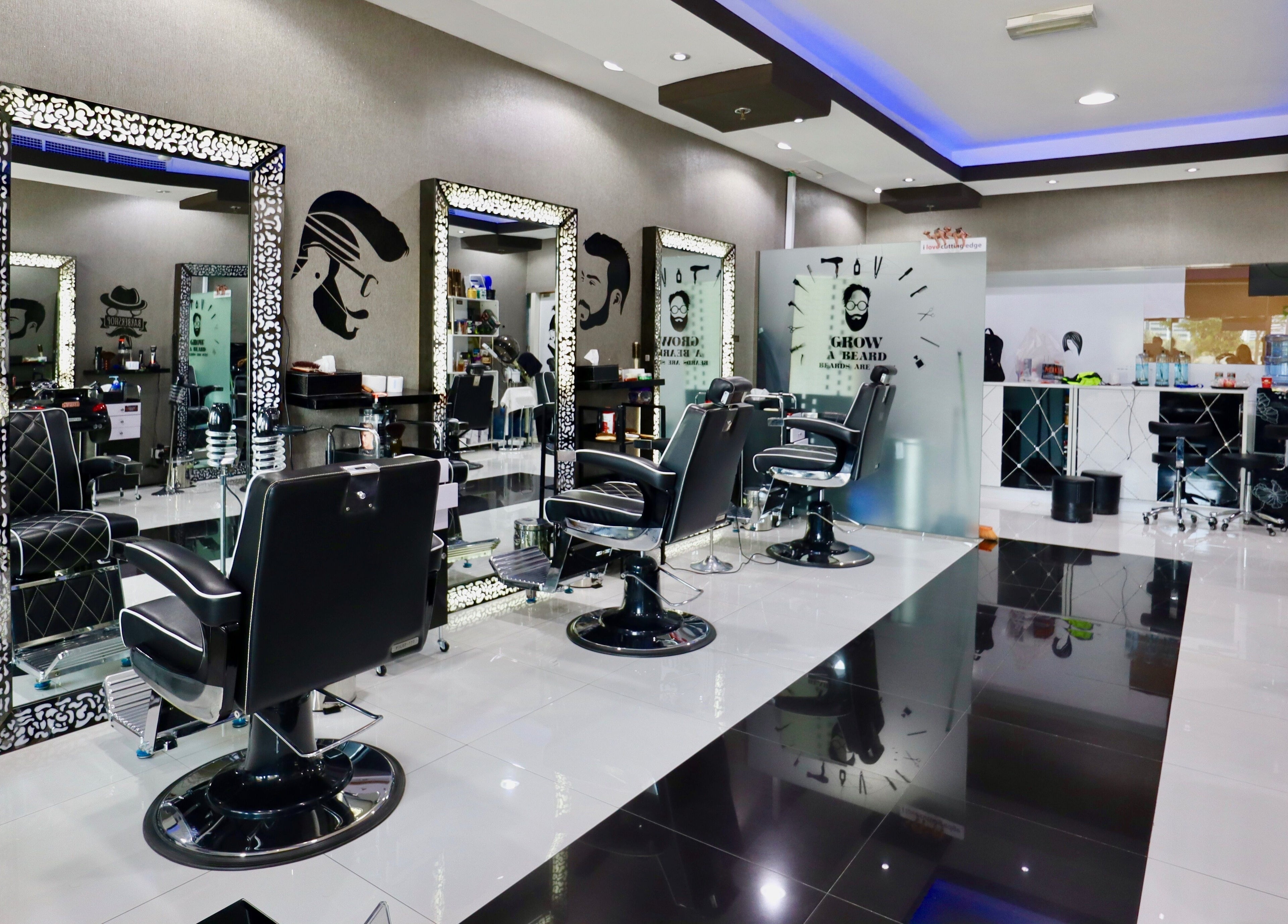 Modern interior of Cutting Edge Gents Salon | Cluster T, featuring sleek black barber chairs. Dubai, AE.