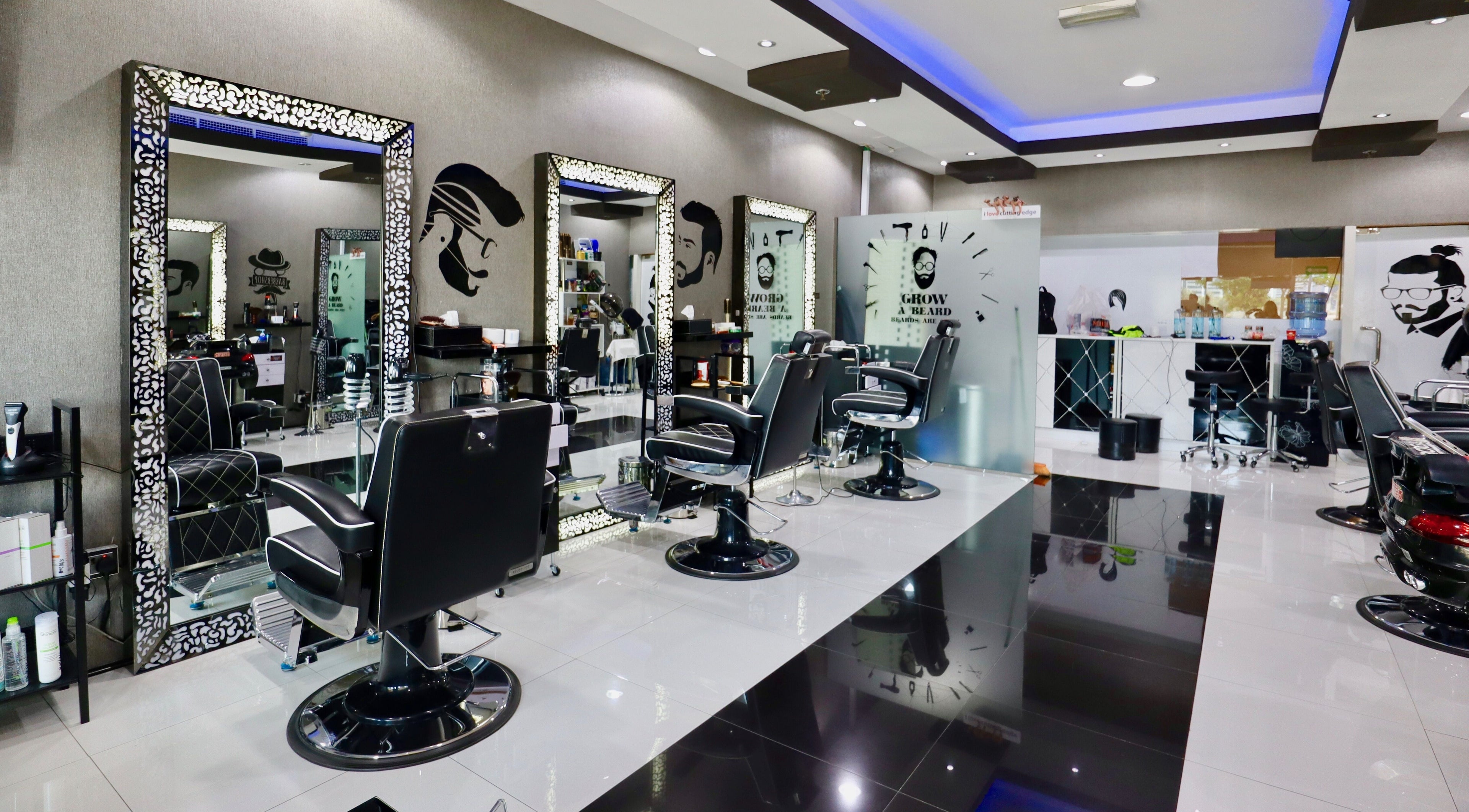 Modern interior of Cutting Edge Gents Salon | Cluster T, featuring sleek black barber chairs. Dubai, AE.