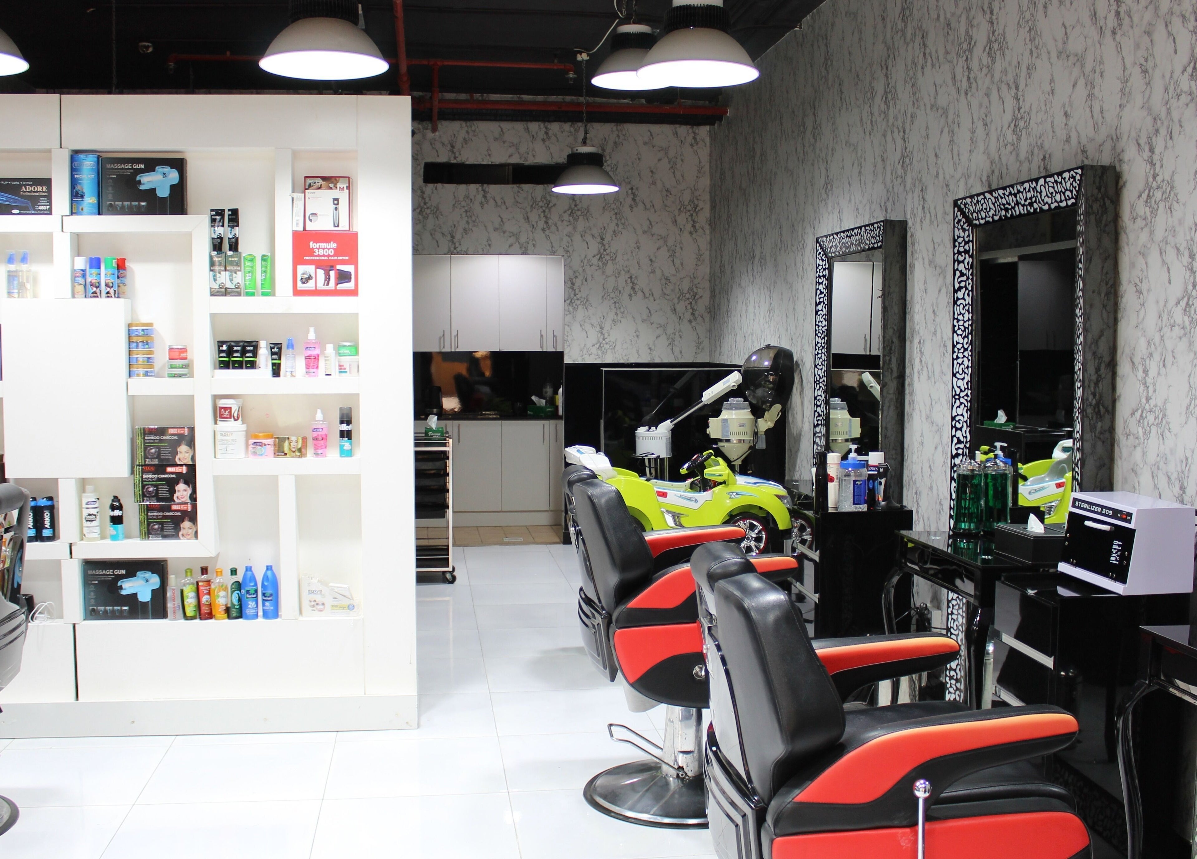 Modern salon interior at Cutting Edge Gents Salon | Cluster P, featuring red chairs and product shelves in Dubai, AE.