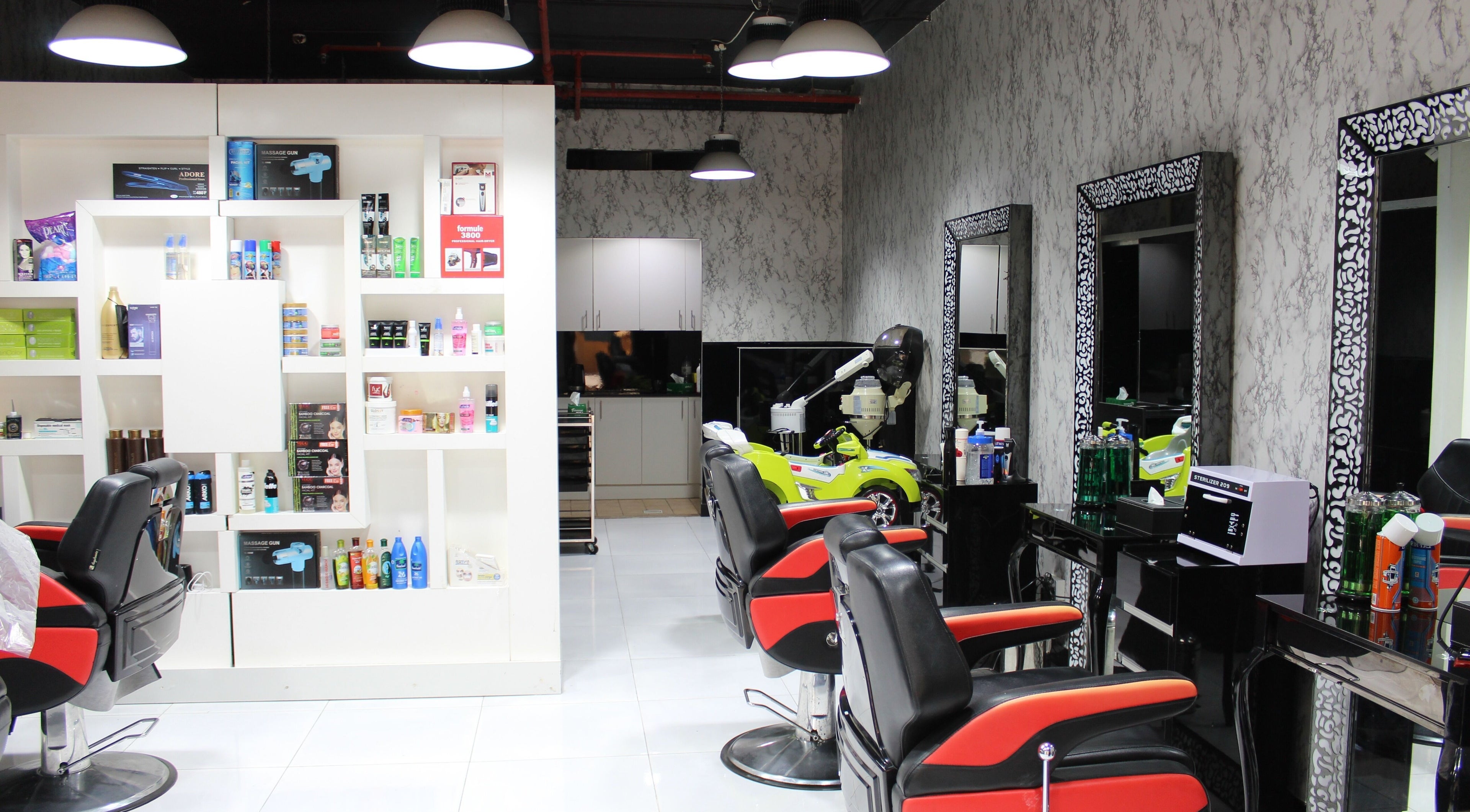 Modern salon interior at Cutting Edge Gents Salon | Cluster P, featuring red chairs and product shelves in Dubai, AE.