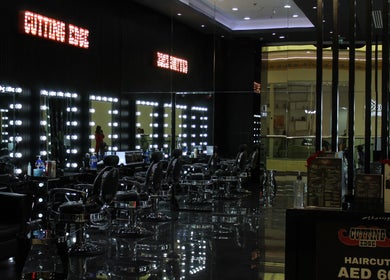 Modern interior of Cutting Edge Gents Salon | IBN Battuta Mall, Dubai, AE with sleek black chairs and mirrors.