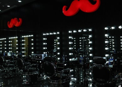 Luxurious interior of Cutting Edge Gents Salon | IBN Battuta Mall, Dubai, AE with illuminated mirrors.