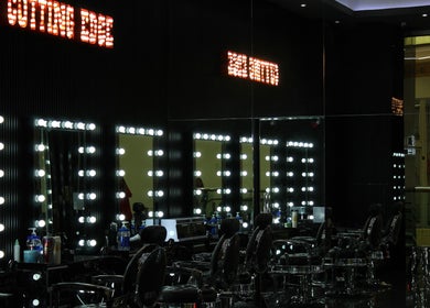 Luxurious interior of Cutting Edge Gents Salon at IBN Battuta Mall, Dubai, AE with illuminated mirrors.
