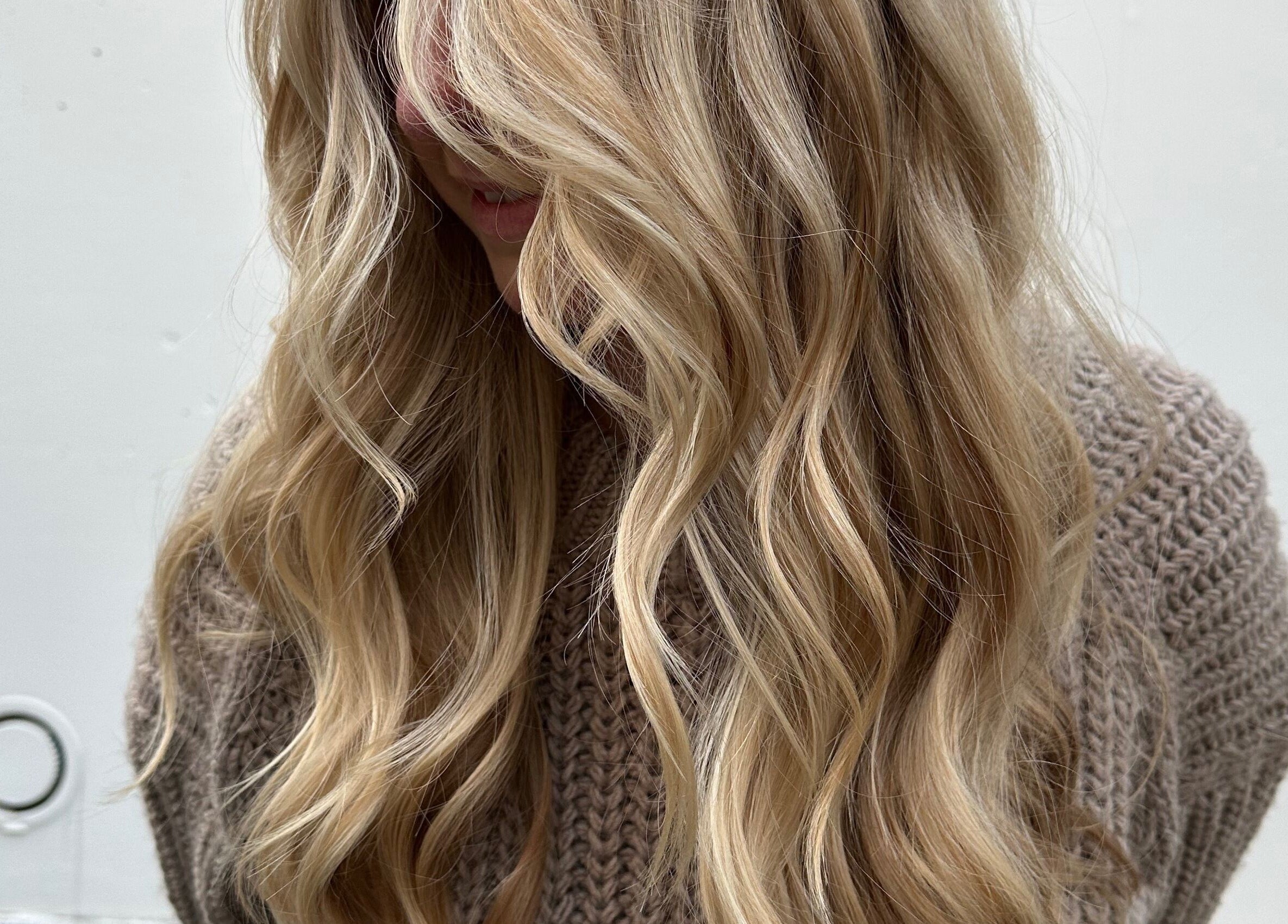 Blonde wavy hair styled at HAIR MAKE il, Shibuya, JP, showcasing elegant curls and shine.