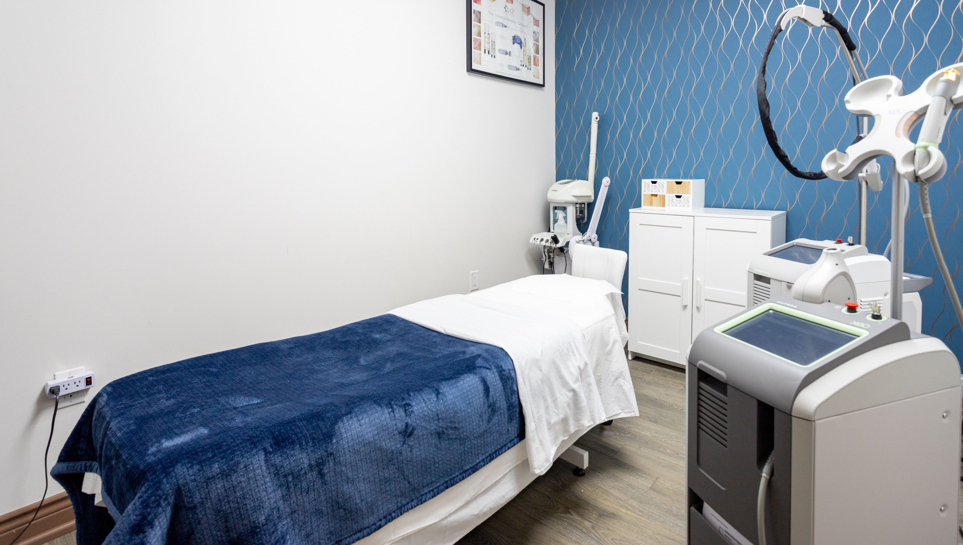 Treatment room at PLC Laser Clinic, Brampton, Ontario, CA, featuring modern equipment and a comfortable bed.
