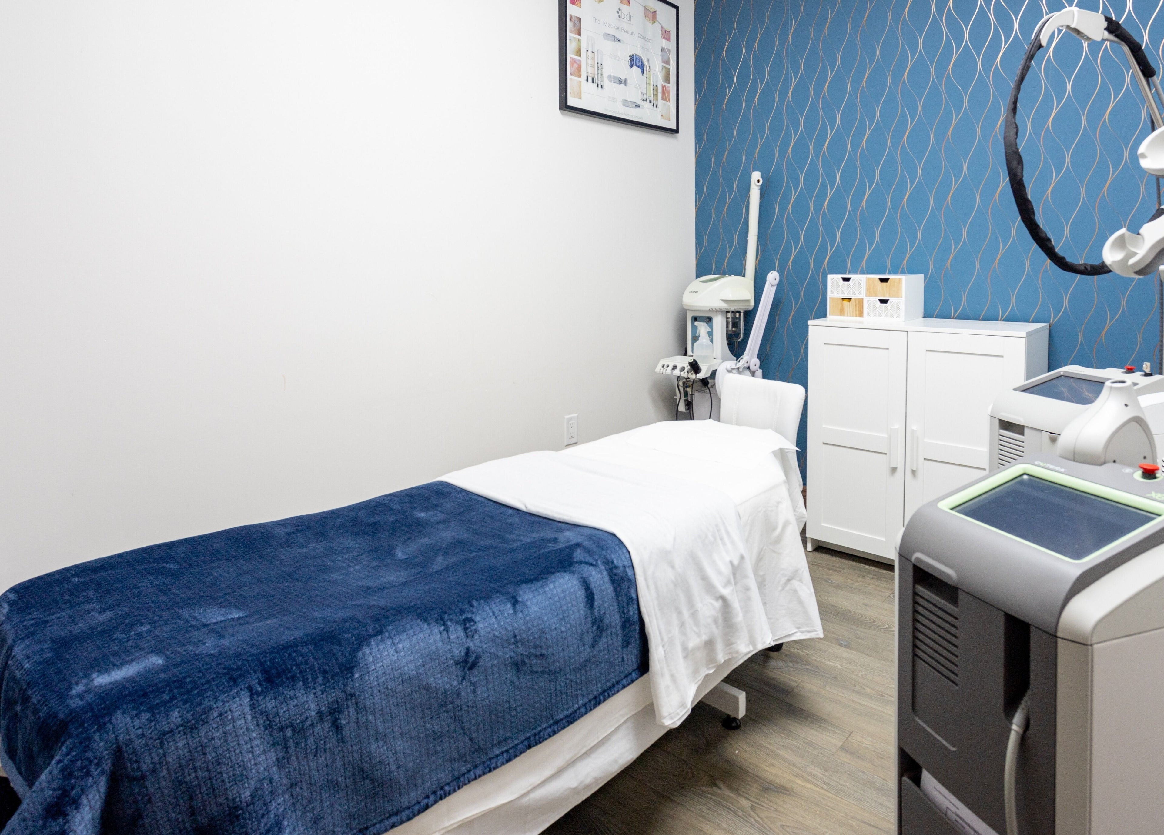 Treatment room at PLC Laser Clinic, Brampton, Ontario, CA, featuring modern equipment and a comfortable bed.