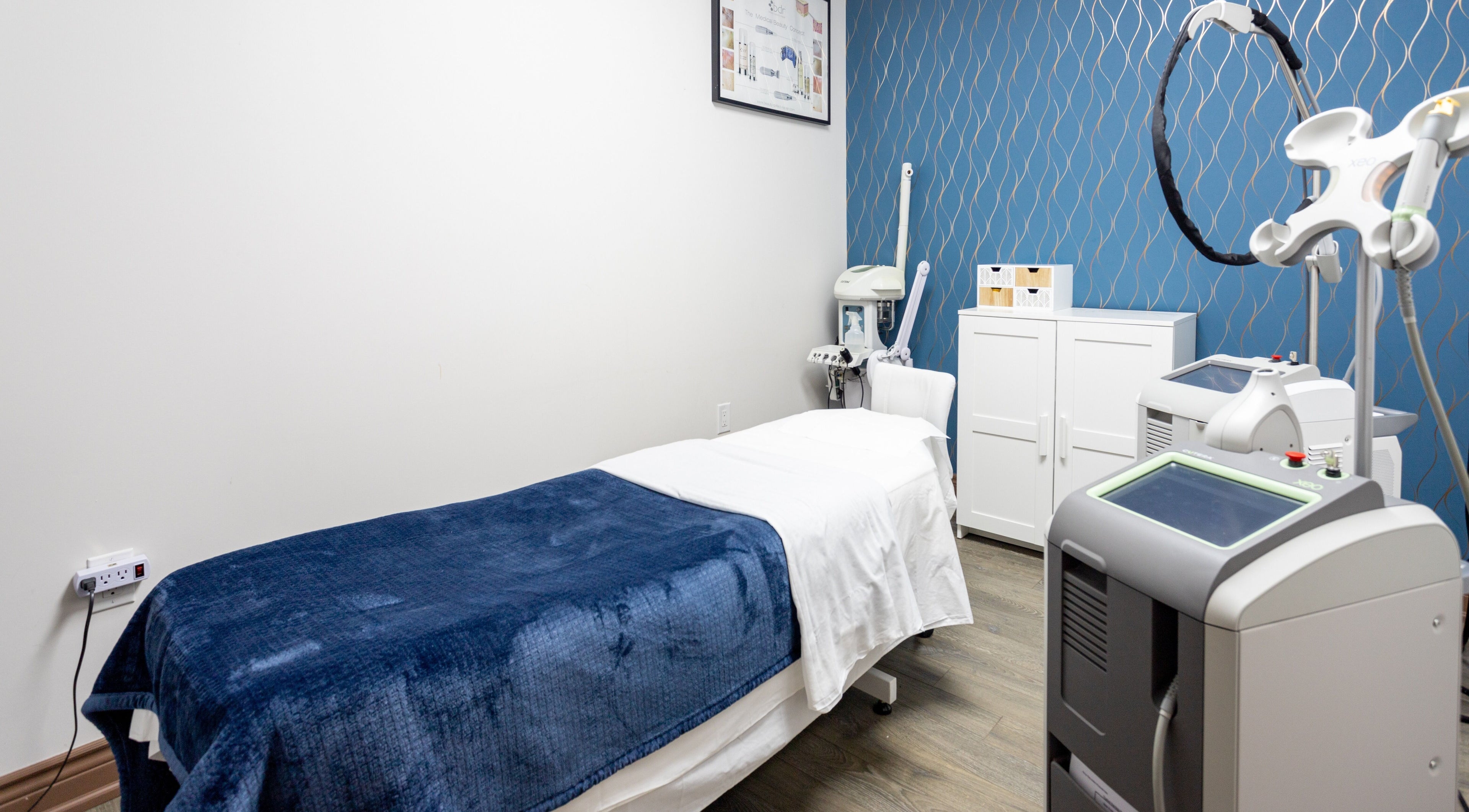 Treatment room at PLC Laser Clinic, Brampton, Ontario, CA, featuring modern equipment and a comfortable bed.