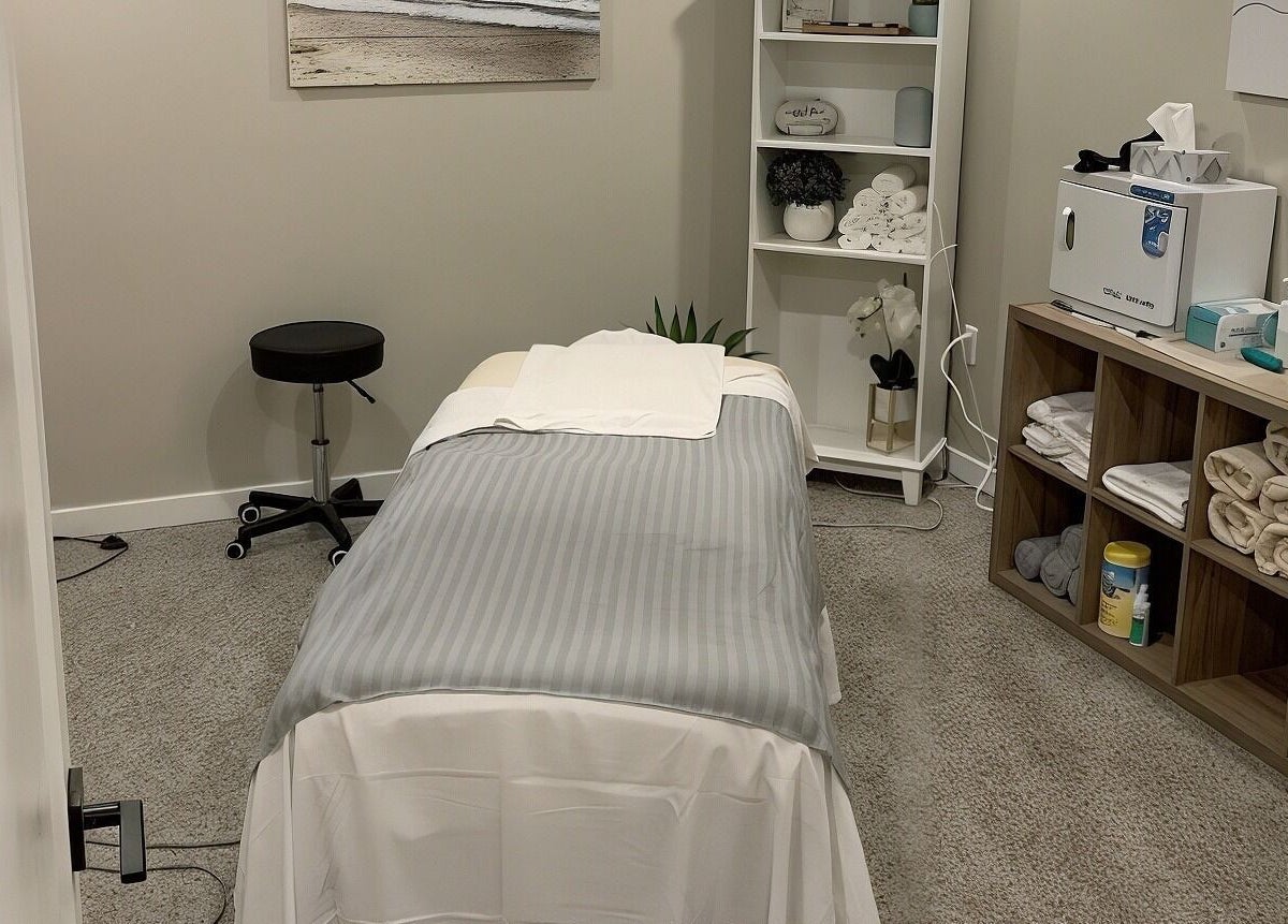 Serene massage room at Clover Therapeutic Wellness Centre in Niagara Falls, Ontario, CA with a cozy treatment bed.