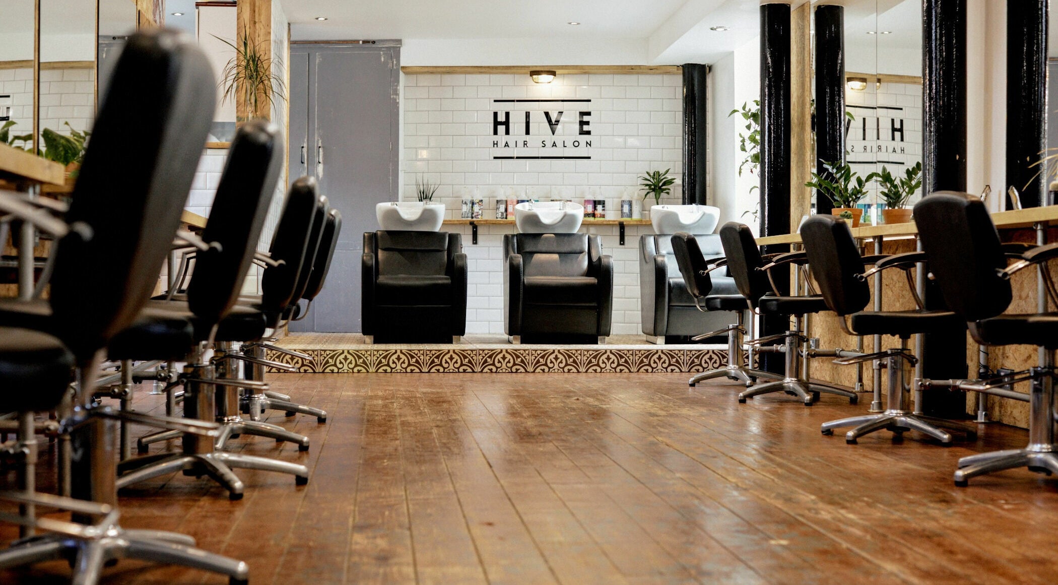 Modern interior of Hive Hair Salon in Leeds, England, GB with styling chairs and sleek washes.
