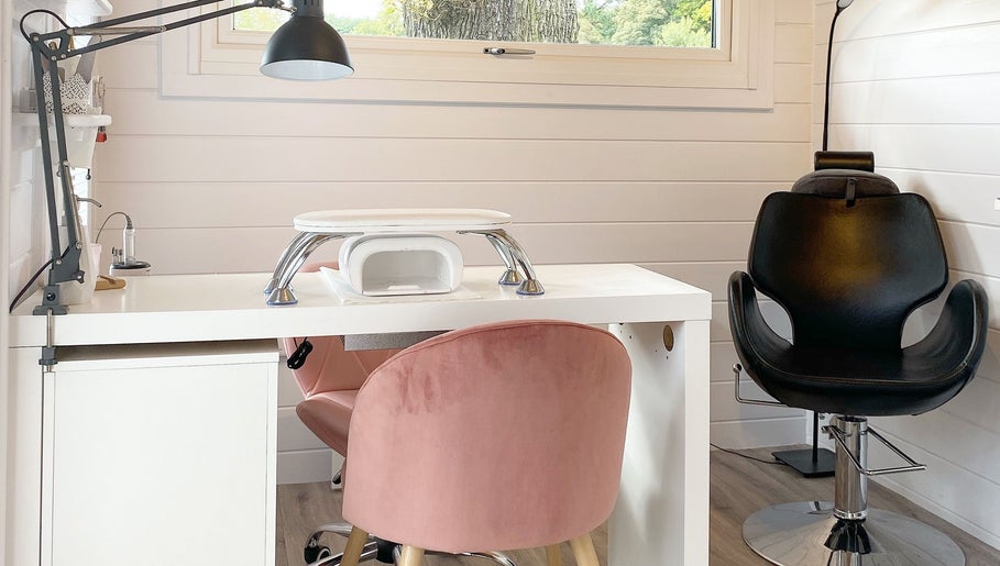 Modern nail station at Hive Nails & Beauty, Silkstone, England, GB featuring cozy pink and black chairs.