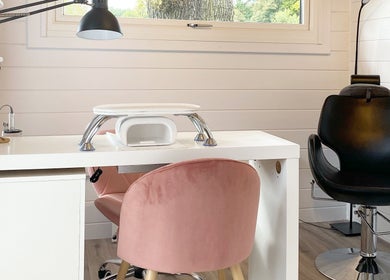 Modern nail station at Hive Nails & Beauty, Silkstone, England, GB featuring cozy pink and black chairs.
