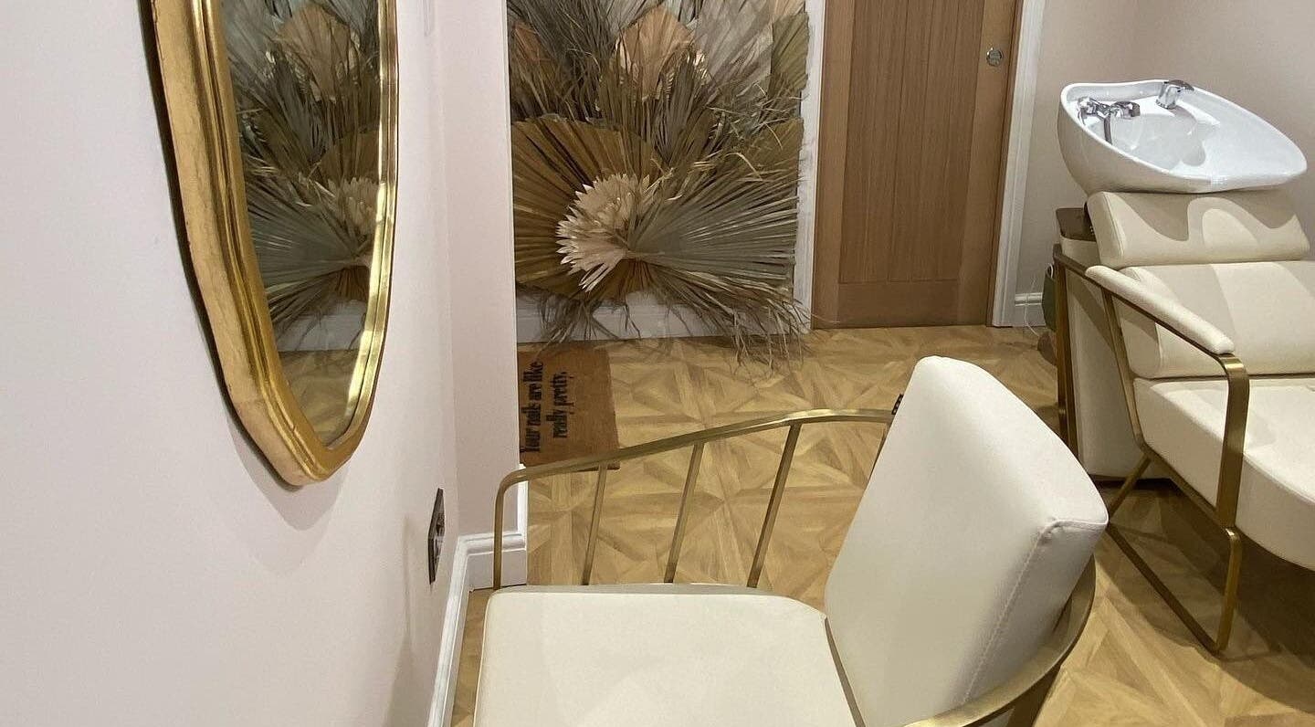 Stylish salon interior at Alice Rose Hair and Beauty in Bristol, England with chic chairs and a wash basin.