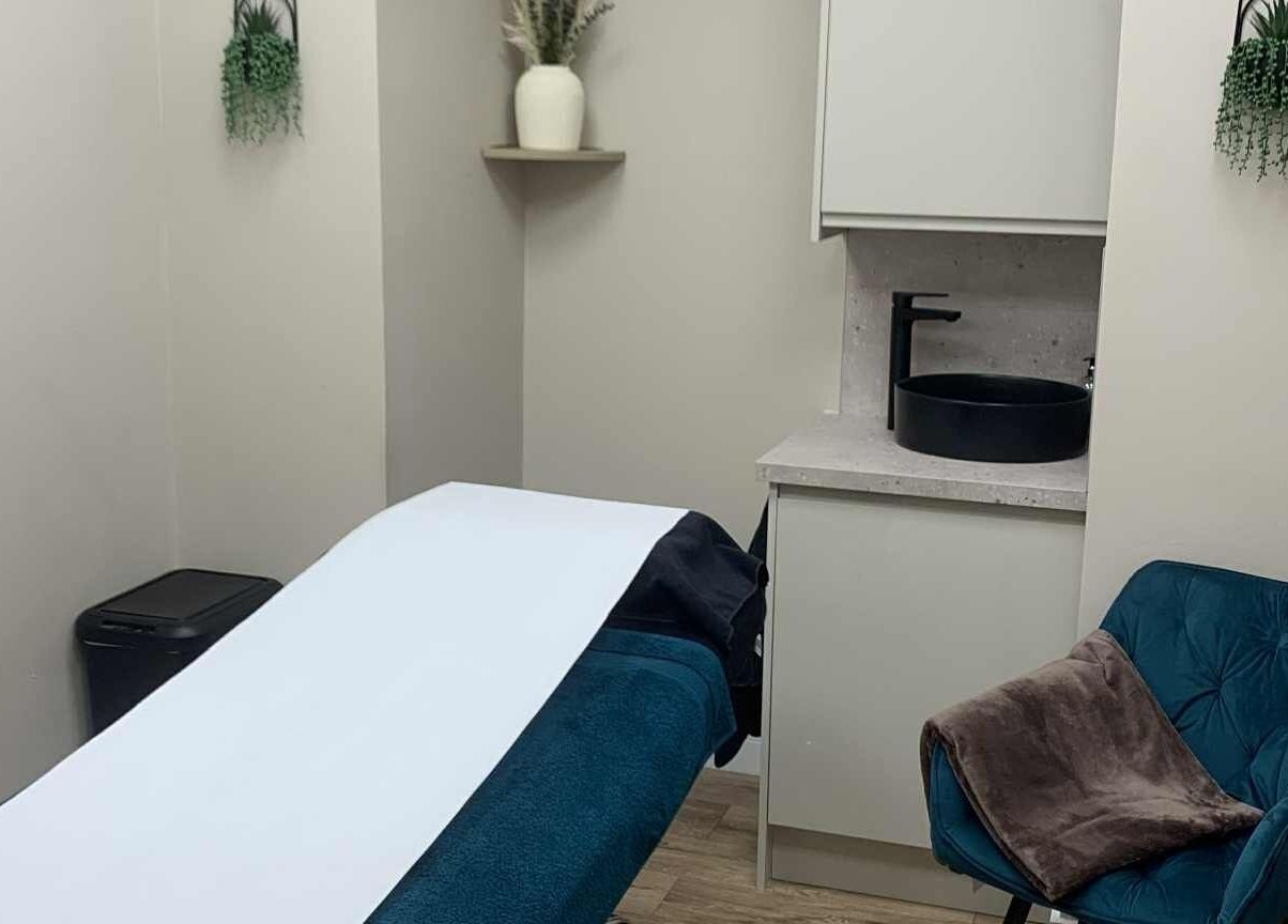 Treatment room at Ruth's Retreat in Douglas, GB, featuring a massage bed, modern decor, and calming ambiance.