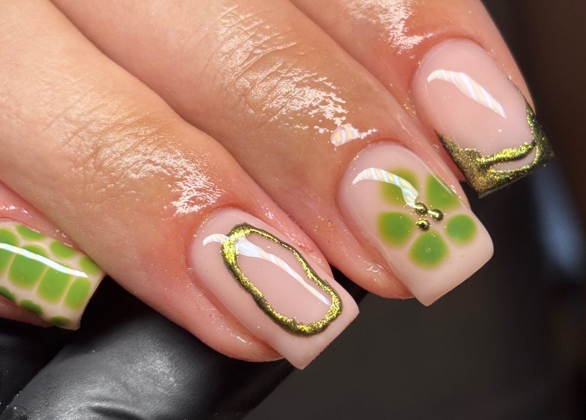 Elegant green nail art at Nails By Cait, Darwen, England, GB, featuring gold accents on manicured nails.