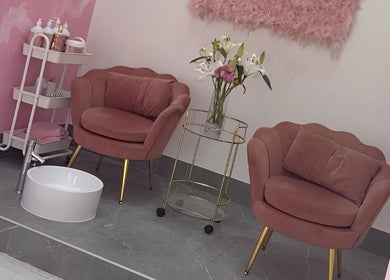 Elegant seating area at Goddess Beauty Boutique, Guisborough, England, GB with pink chairs and floral decor.