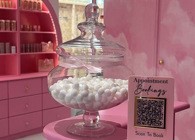 Chic interior of Goddess Beauty Boutique in Guisborough, England, with pink decor and appointment booking sign.