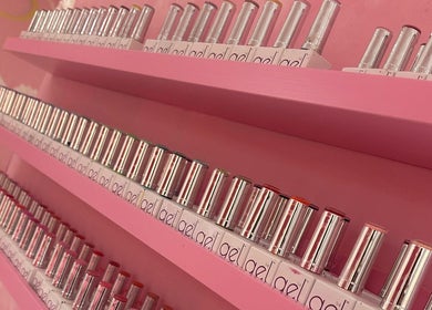 Colorful nail polish bottles on pink shelves at Goddess Beauty Boutique, Guisborough, England, GB.