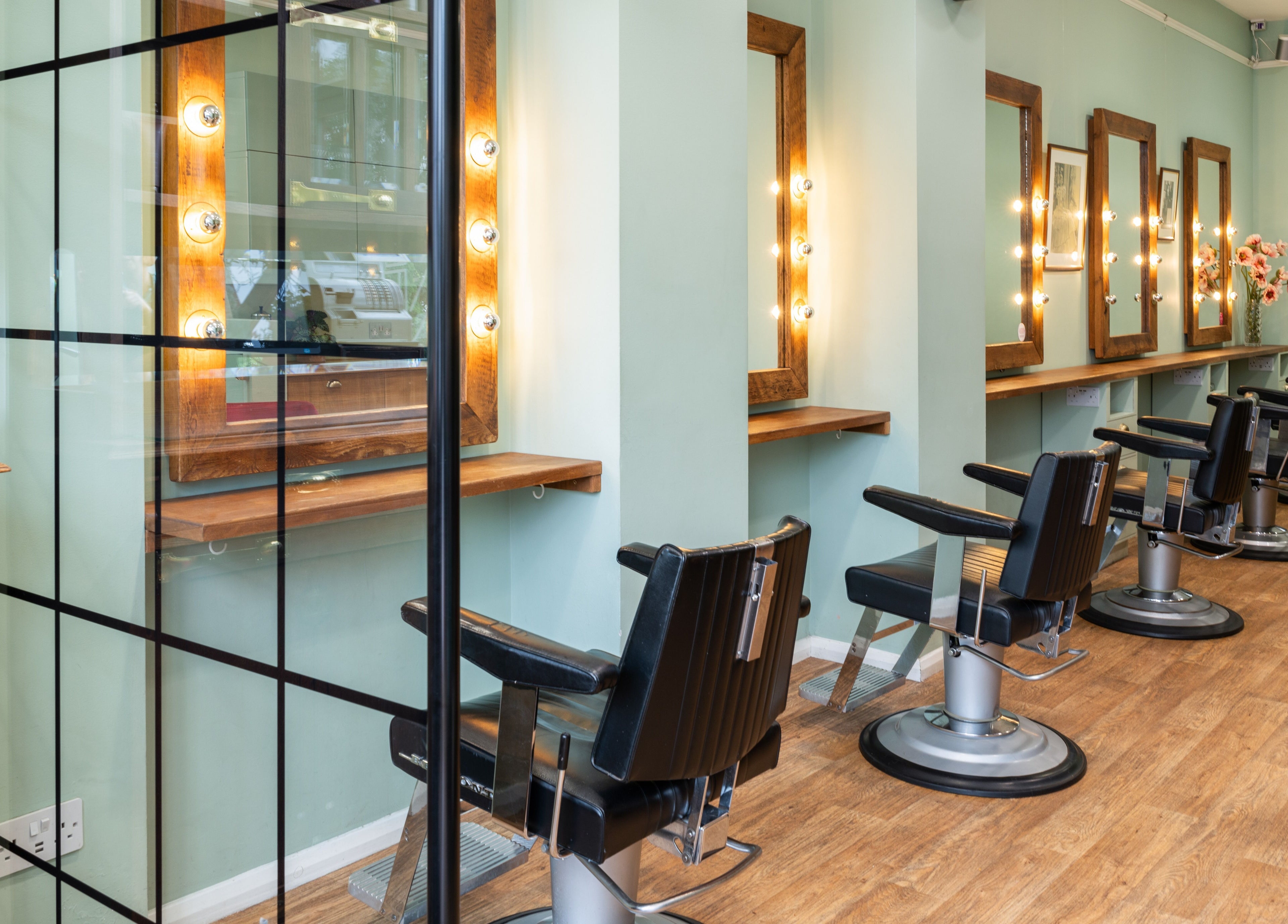 Elegant barber chairs and mirrors at Lisa Hauck, London, England, GB. Modern salon interior design.