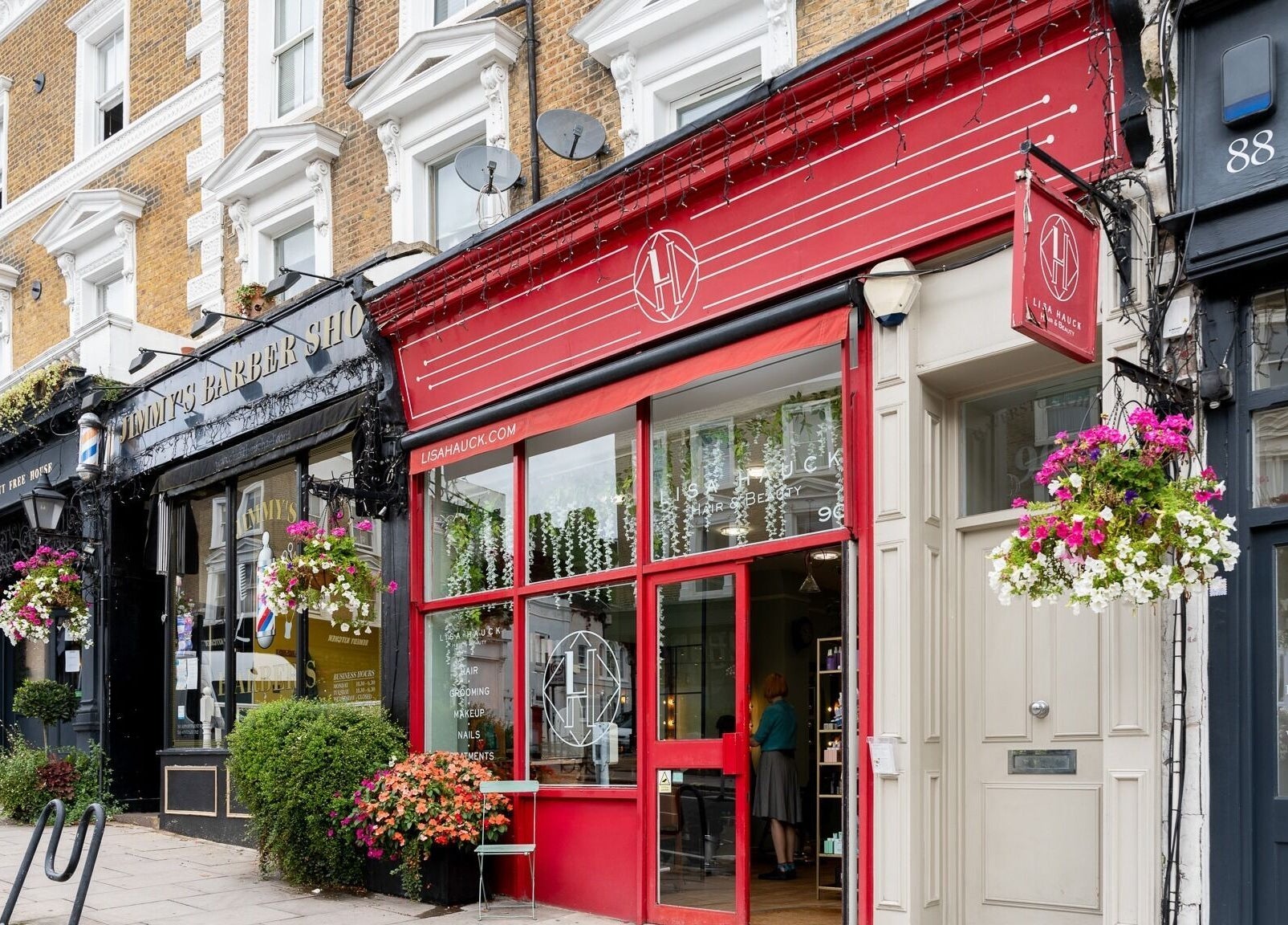 Charming facade of Lisa Hauck salon in London, England, GB with bright red accents and floral display.