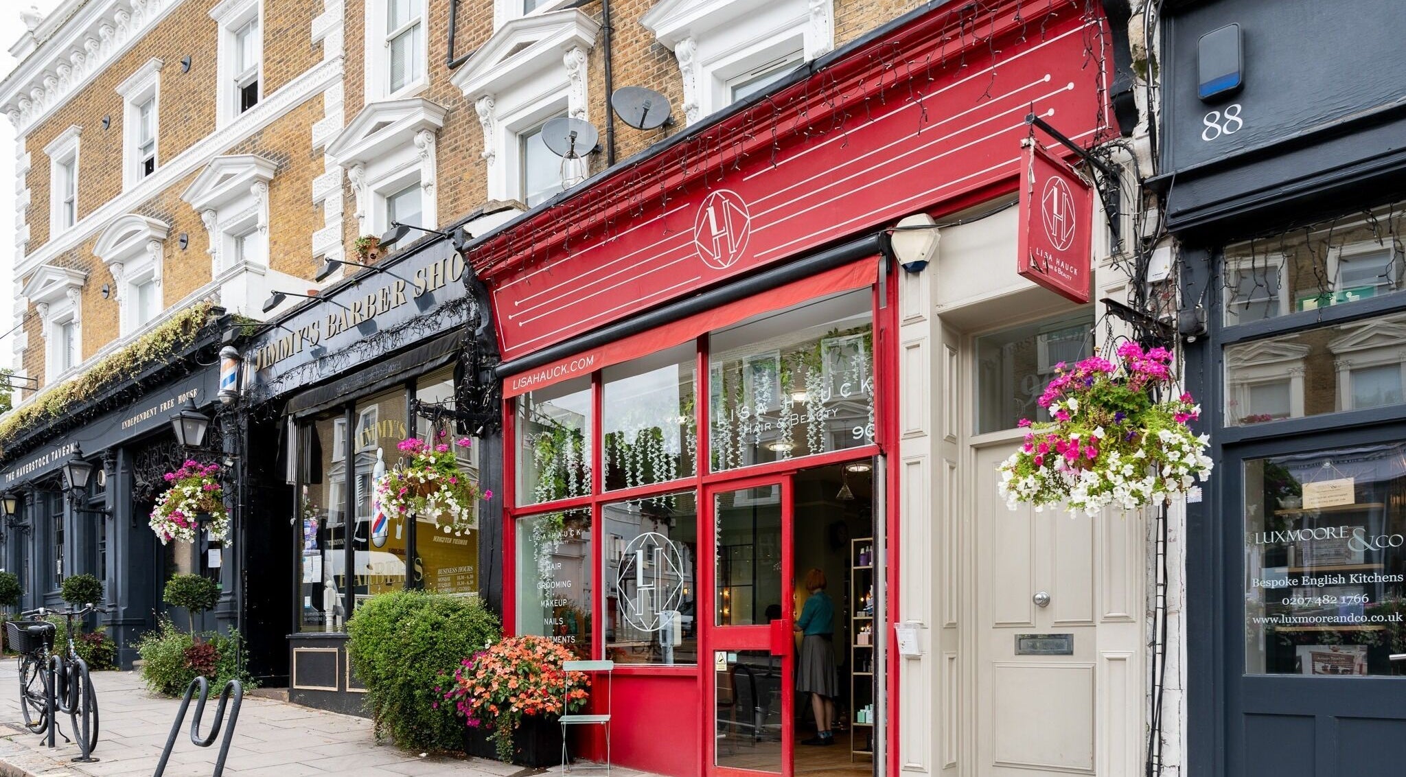 Charming facade of Lisa Hauck salon in London, England, GB with bright red accents and floral display.