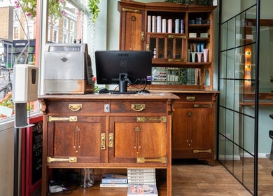 Elegant wooden salon workstation at Lisa Hauck, London, England, GB, featuring stylist tools and products.