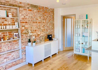 Bridge Street Skin Clinic's stylish reception in Hungerford, England with brick walls and product displays.