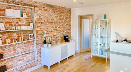 Bridge Street Skin Clinic's stylish reception in Hungerford, England with brick walls and product displays.