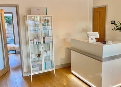 Reception area at Bridge Street Skin Clinic, Hungerford, England, GB with a modern counter and display cabinet.