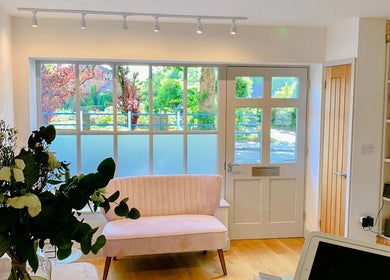Cozy and inviting interior of Bridge Street Skin Clinic in Hungerford, England, GB with natural lighting and greenery.
