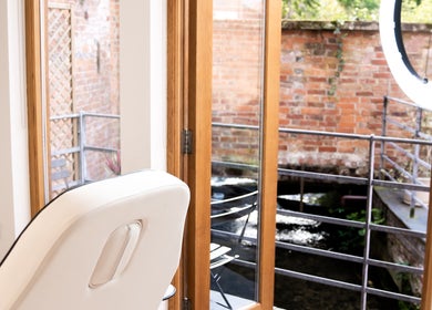 Bright treatment room at Bridge Street Skin Clinic, Hungerford, England, with natural light and tranquil patio view.