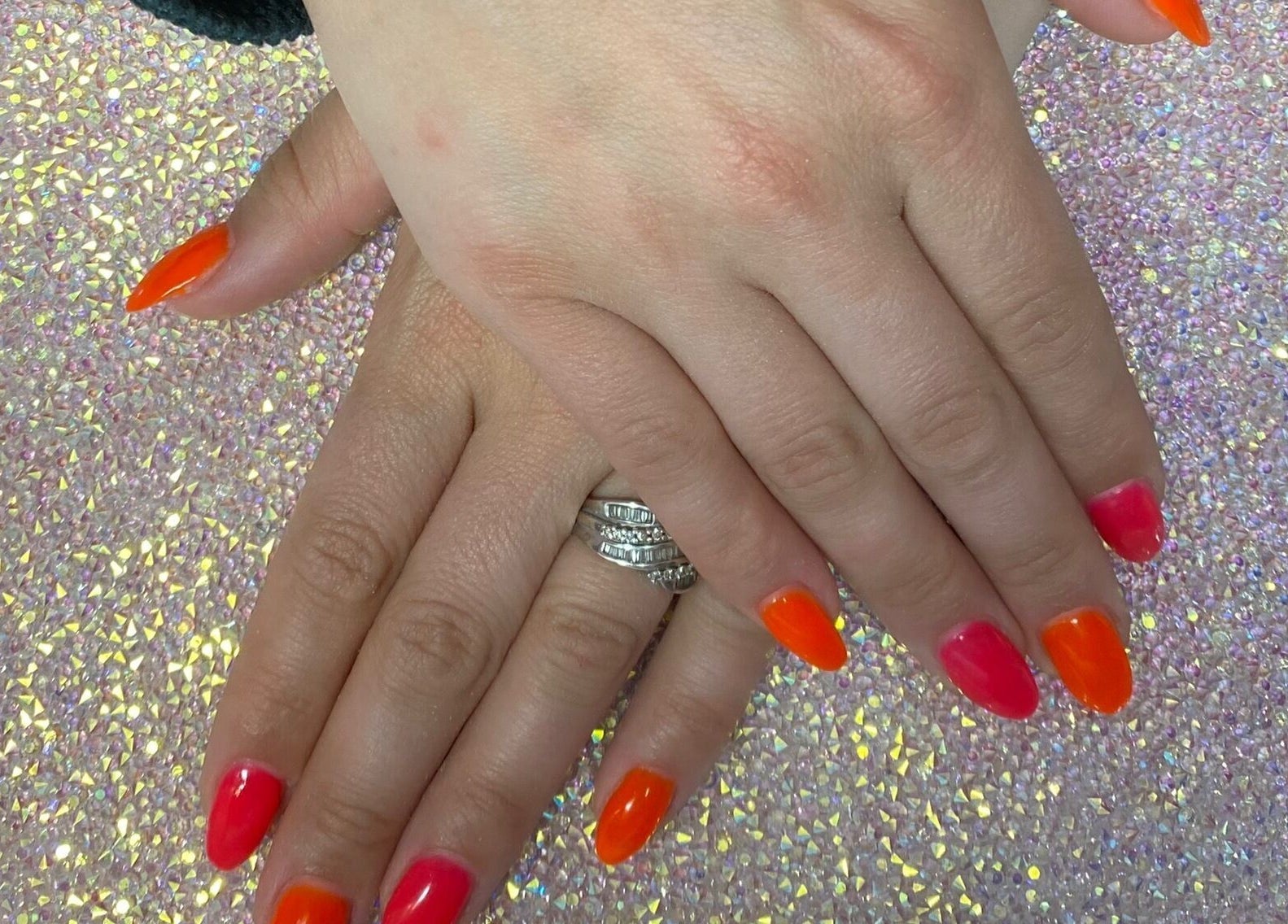 Colorful nails at Twinkle Toes and Fingers & Aesthetics, Taverham, England, GB with glittering backdrop.