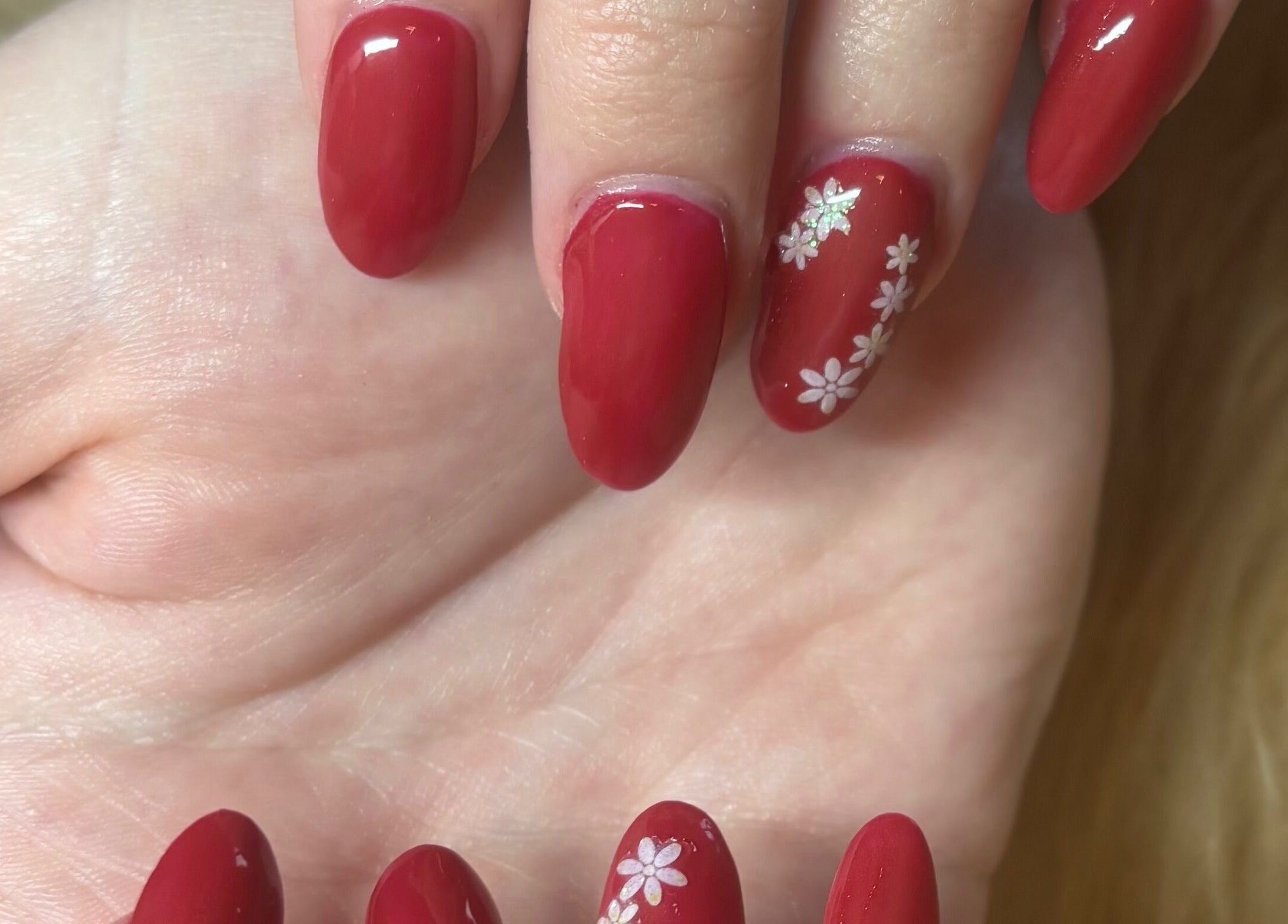 Elegant red manicure with floral design at Twinkle Toes and Fingers & Aesthetics, Taverham, England, GB.