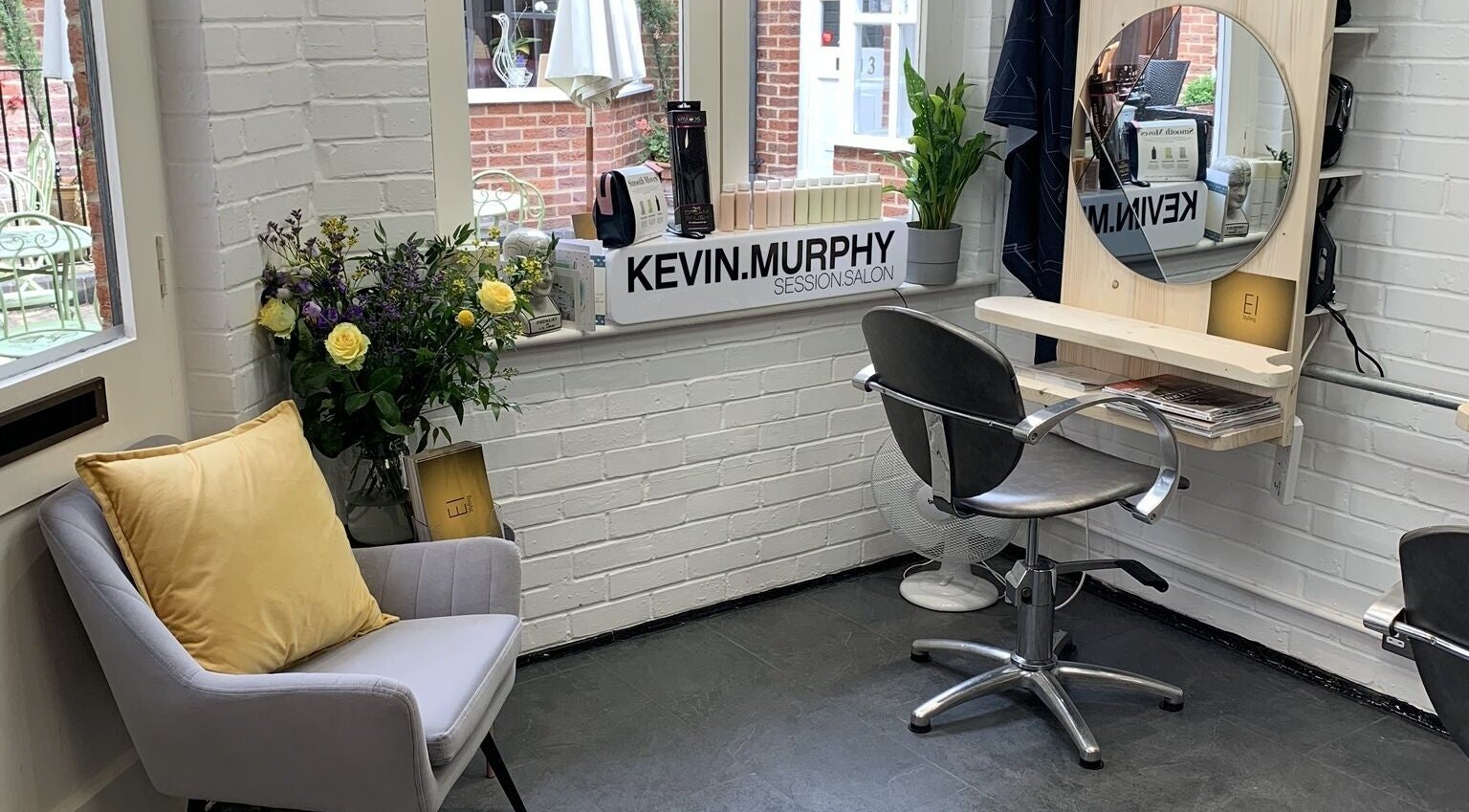 Eistyling salon corner with chair, mirror, and plants in Bedford, England, GB.