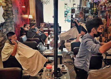 Customers receiving haircuts at Inch Hair Salon, Kajang, Selangor, MY with chic decor.