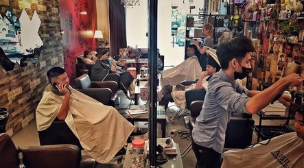 Customers receiving haircuts at Inch Hair Salon, Kajang, Selangor, MY with chic decor.