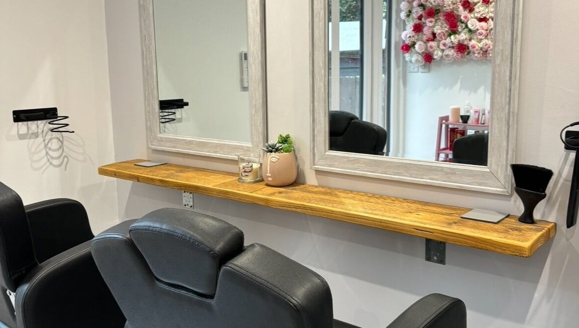 Stylish hairdressing station at Lenice Kennedy Hair in Burton Latimer, England, GB with a mirror and floral decor.