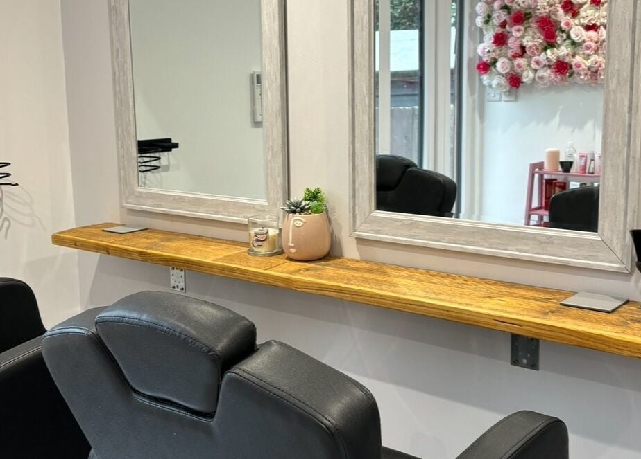 Stylish hairdressing station at Lenice Kennedy Hair in Burton Latimer, England, GB with a mirror and floral decor.