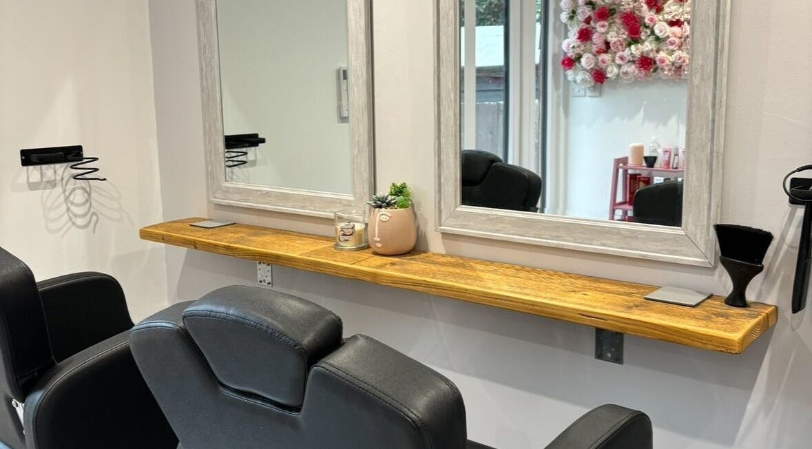 Stylish hairdressing station at Lenice Kennedy Hair in Burton Latimer, England, GB with a mirror and floral decor.