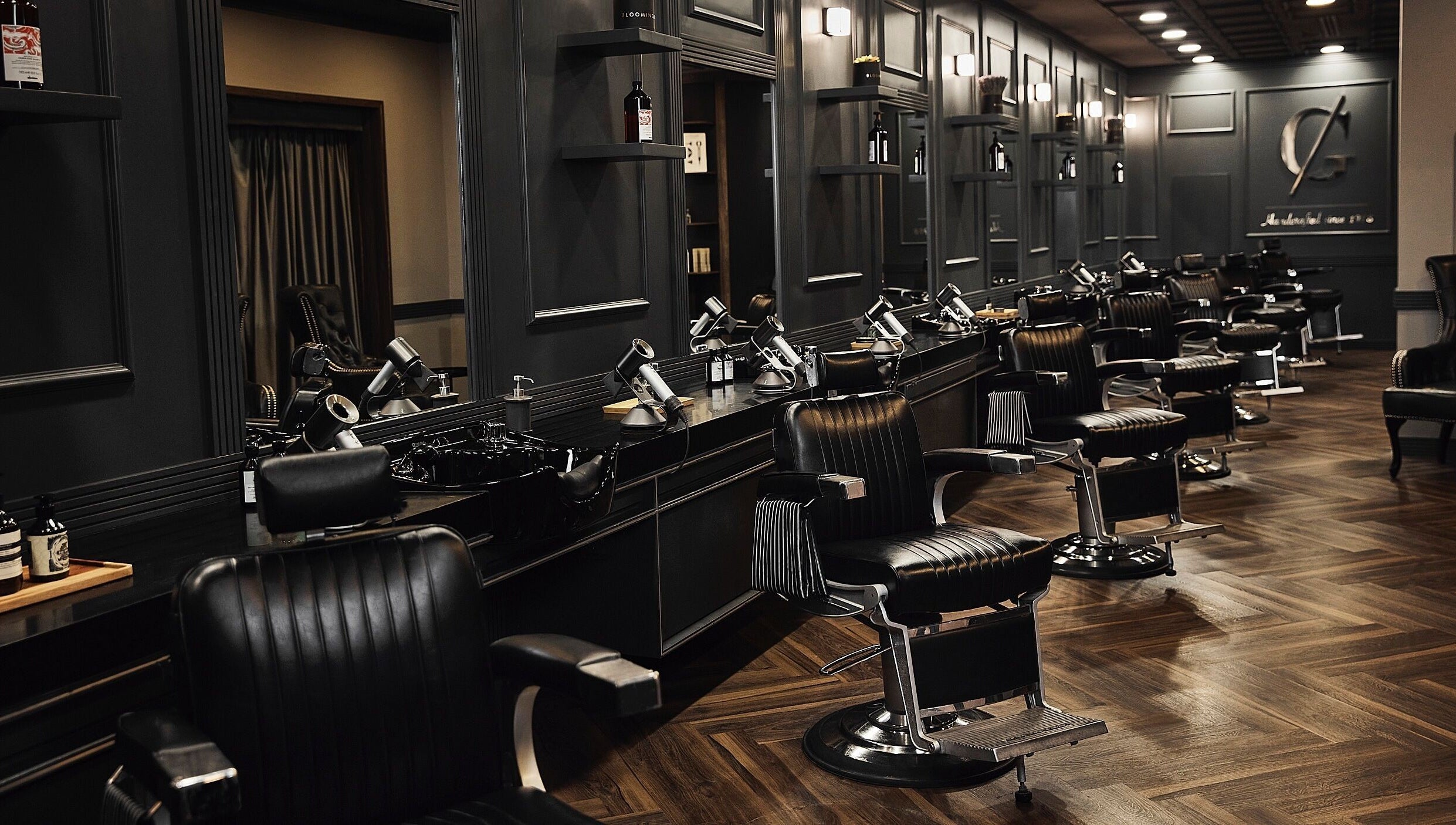 Chic barber chairs in CG Barbershop, Dubai, AE, showcasing a sleek, modern interior with dark wood accents.