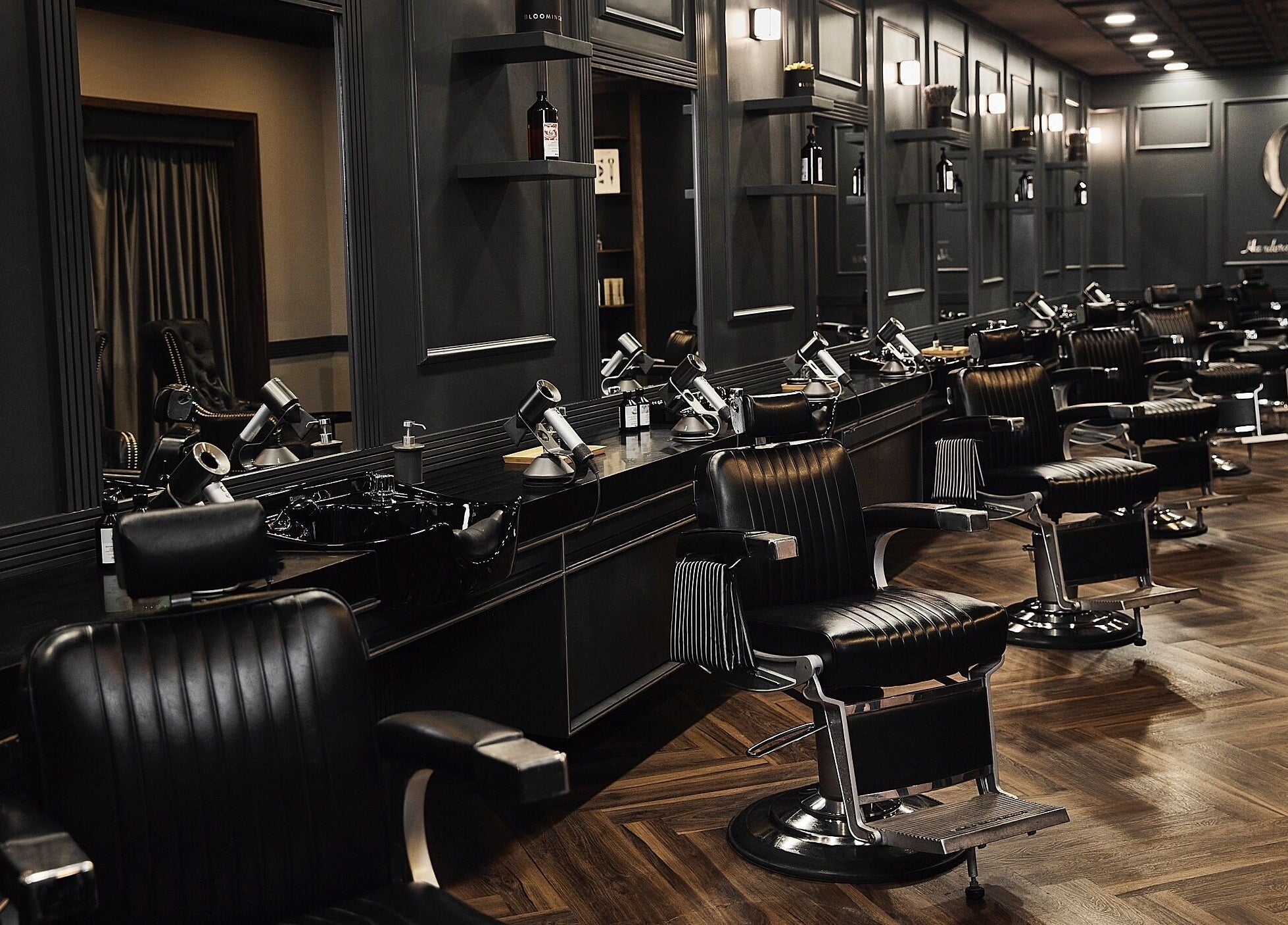 Chic barber chairs in CG Barbershop, Dubai, AE, showcasing a sleek, modern interior with dark wood accents.