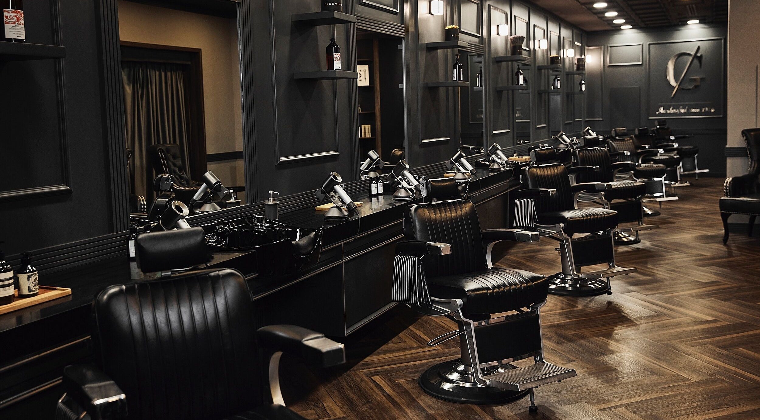 Chic barber chairs in CG Barbershop, Dubai, AE, showcasing a sleek, modern interior with dark wood accents.