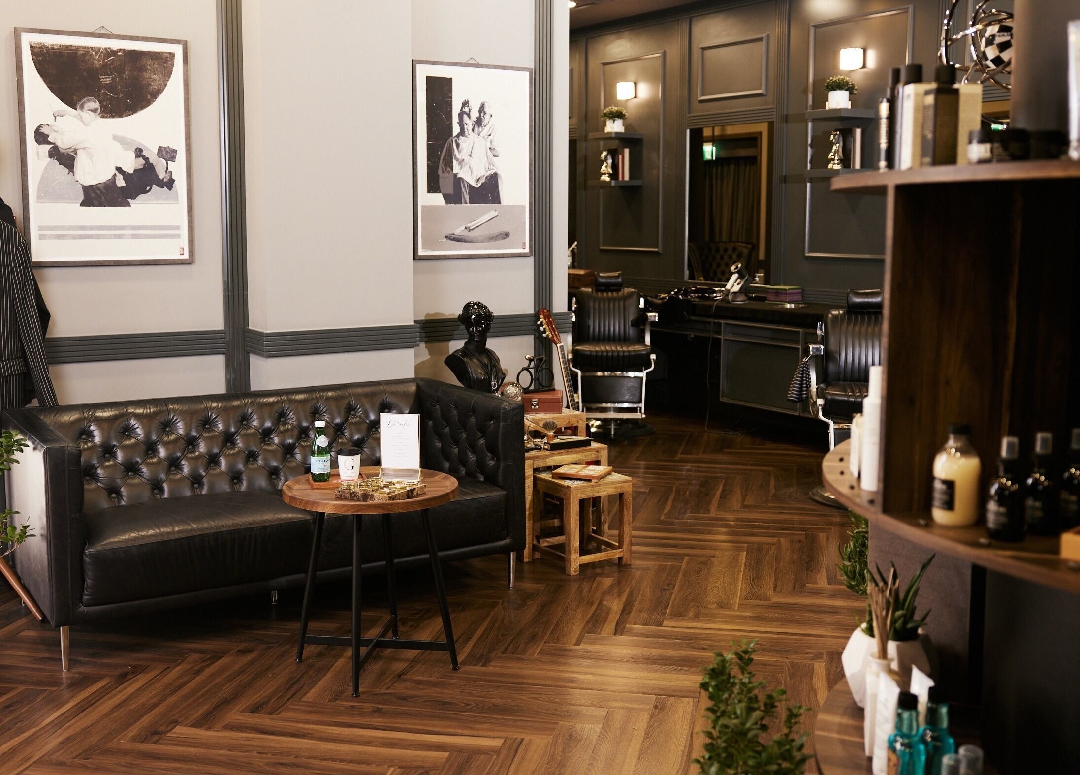 Stylish interior of CG Barbershop, Dubai, AE, featuring vintage decor, leather sofa, and grooming products.