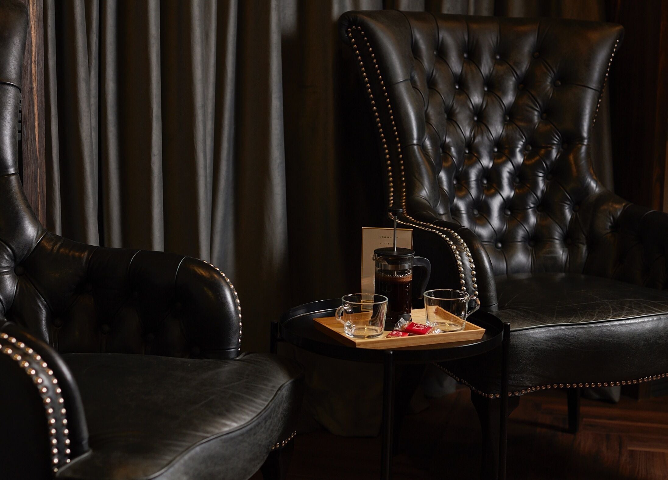 Luxurious black leather chairs at CG Barbershop in Dubai, AE, offering comfort and style.